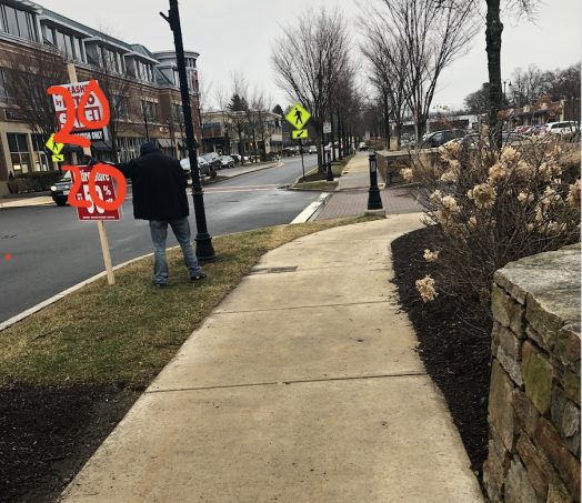 guy holding sign in Linden Square